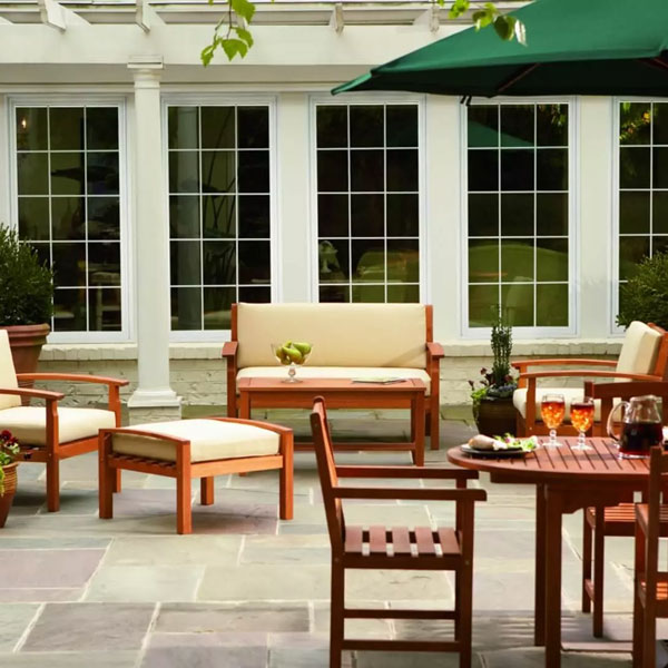 home backyard with various outdoor furniture next to large set of windows